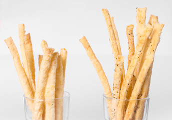 bread sticks in a glass on a white background