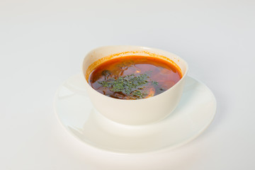 a plate of soup with greens on a white background