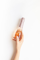 Bottle of rose champagne wine in woman hand