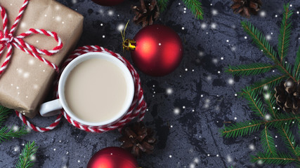 Hot cocoa in a mug on the holiday table with Christmas gifts and spruce branches