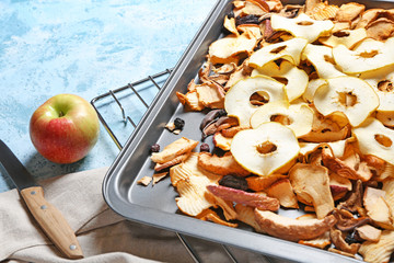Baking sheet with dried fruits on color background