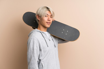 Young asian man over isolated background with skate © luismolinero