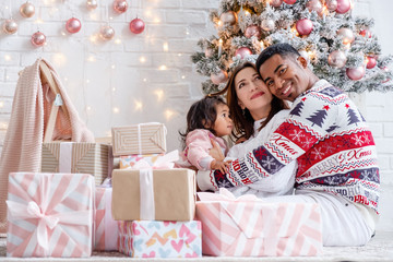 Happy mixed race family african american dad mom and daughter rejoice celebrating Christmas sitting...