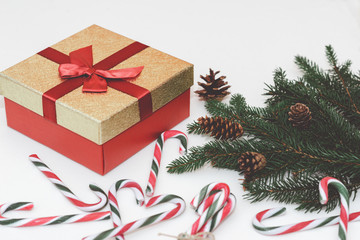 Christmas concept, new year concept. Gift Box, candy staff,candy canes Christmas tree branches. Fir tree branches,close up.Toned.White background.