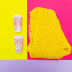 Fototapeta na wymiar Fashion set of knitted cozy cardigan with two cups of coffee on fuchsia, purple and bright yellow background