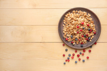 Plate with tasty granola on table