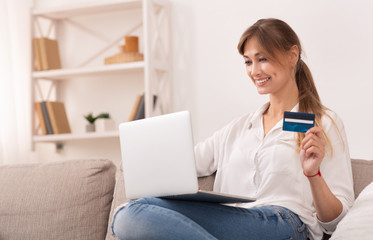 Happy Woman Holding Credit Card Using Laptop Shopping At Home
