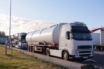 Road transport. Trucks transporting various goods. Photo shows a tanker and a truck for transporting passenger cars.