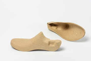 Pair of shoe trees made of recycled paper on white background.