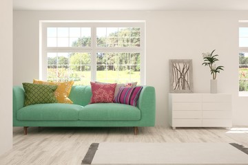 Fototapeta premium Stylish room in white color with sofa and summer landscape in window. Scandinavian interior design. 3D illustration