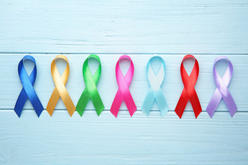 Different awareness ribbons on color wooden background
