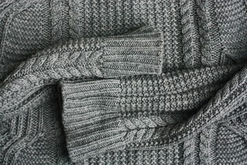 Fototapeta na wymiar Beautiful knitted grey sweater close up view