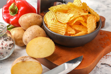 Tasty potato chips, spices and bell pepper on table