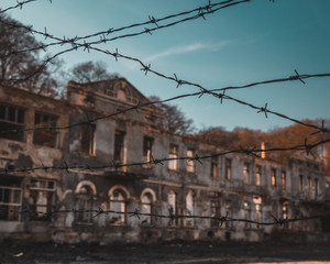 Scenic view of an barbed wire toward abandoned winery, old building