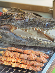 Fried crocodile meat mixed with crushed garlic on skewers. Street food in Bangkok, Thailand.
