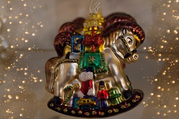 Christmas decorations - rocking horse with gifts. Christmas decorations - rocking horse with gifts. Isolated Christmas decorations in a row. Christmas lights on the sides.