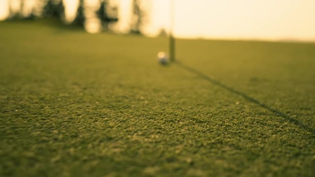 Putting Golf Ball on green in golf course hitting the golf ball to hole for birdie score, sports relax in holidays summer vacation at sunset golden time, cinematic Slow motion footage
