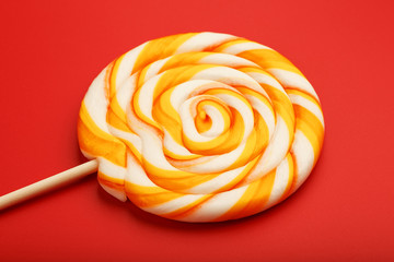 Colorful round Lollipop, on red background. Minimal concept with copy space.