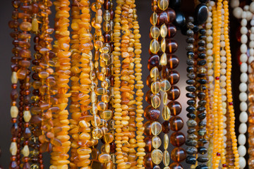 Amber background of beads and necklaces at the handicraft market. Jewelry design