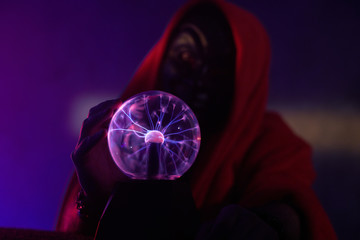 Dark creature is holding in his hands a magic globe with static electricity.