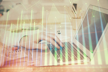 Double exposure of stock market graph with man working on laptop on background. Concept of financial analysis.