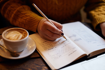 Fototapeta na wymiar Woman sketching web design in her diary
