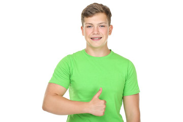 Obraz premium Portrait of young man with dental braces showing thumb up on white background
