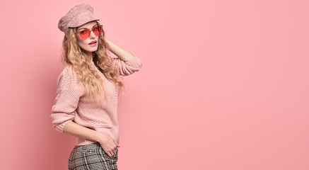 Fashionable woman in Trendy pink outfit, stylish hairstyle, makeup smiling. Young blonde in jumper,...