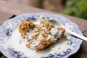 crumble de manzana con crema en plato azul y cuchara