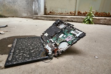 Broken up laptop on the ground, smashed to pieces