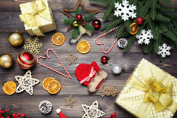 Gift boxes with fir tree branches and ornaments on brown wooden table