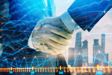 Double exposure of financial graph on cityscape background with two businessman handshake. Concept of stock market deal