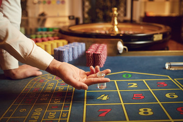 Croupier hand pointing to a winning combination on the roulette in a casino.