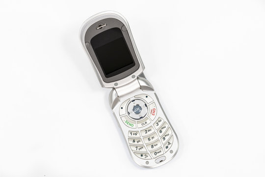 Cute little old flip style cell phone with white background.  