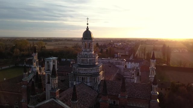 4k aerial drone orbit footage at sunset time of abbey of Pavia, ancien and prestigious italian monument.
