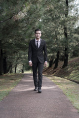 Young Asian Malay Man at the park wearing suit