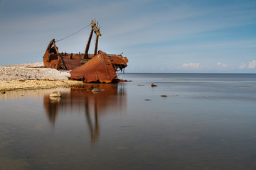 Old rusty wreck and rocky beach in Baltic Sea, natural environment. Osmussaar, Estonia, Europe.