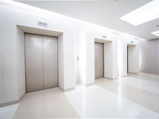 Modern steel elevator cabins in a business lobby or Hotel, Store, interior, office,perspective wide angle. Three elevators in hotel lobby.