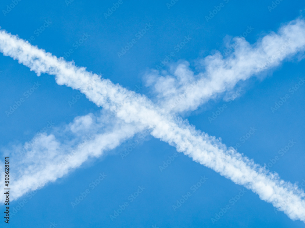 Aufkleber Traces of planes intersect in the blue sky