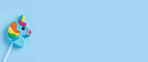 lollipop unicorn on a blue background. Panorama, banner. © Nizoli