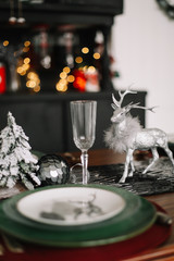 Festive table setting for Christmas dinner at home. New year and Christmas decorations. Winter holiday theme. Happy New Year.