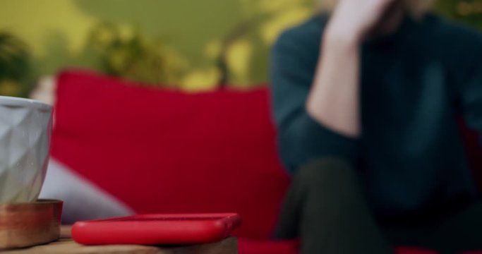 Incoming Call To Modern Smartphone Lying On Table In The Living Room. Close-up. Young Scared Man Hesitating To Answer Mobile Phone Call From Important Person.