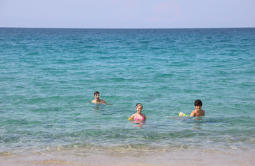 two boy and a little girl on the water of ocean