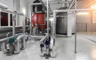 interior of modern industrial boiler room with boilers, pumps, pressure gauges and pipes for gas...
