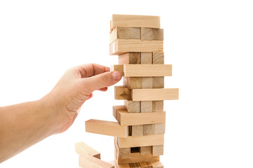 Planning, risk and strategy in business, hand gambling placing a wooden block on a tower. Wooden blocks isolated on a white background.