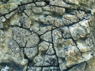 Abstract background. Rough cracked stone wall, cracks closeup