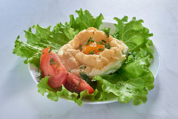 Baked Eggs Orsini, salad and tomatoes on plate for breakfast.