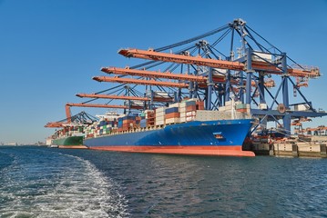 Fototapeta premium Huge container ships in port being loaded in Rotterdam