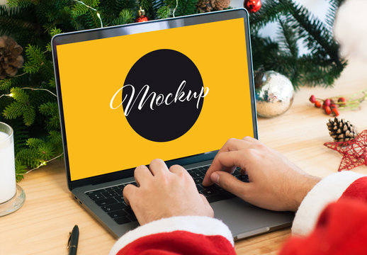 Santa Claus Using a Laptop with Christmas Decorations Mockup