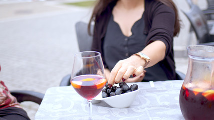 Young woman eats olives in a street restaurant - travel photography